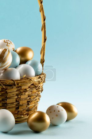 Photo for Image of multi coloured easter eggs in basket and copy space on blue background. Easter, religion, tradition and celebration concept. - Royalty Free Image
