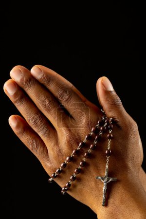 Foto de Imagen de cerca de las manos de una mujer afroamericana rezando con rosario. Pascua, religión, tradición y concepto de celebración. - Imagen libre de derechos