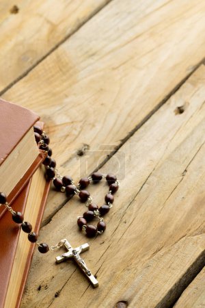 Imagen de primer plano de dos sagradas biblias con rosario y espacio de copia sobre fondo de madera. Pascua, religión, tradición y concepto de celebración.