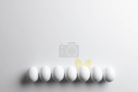 Photo for Image of row of white easter eggs with bunny ears and copy space on white background. Easter, religion, tradition and celebration concept. - Royalty Free Image