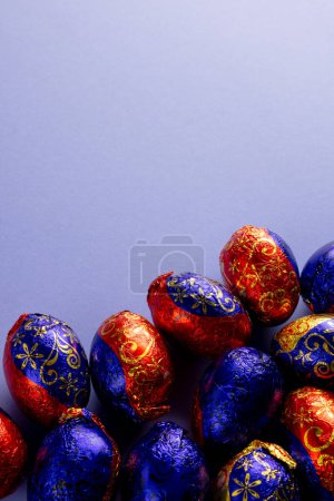 Téléchargez les photos : Image d'oeufs de Pâques multicolores en chocolat avec espace de copie sur fond violet. Pâques, religion, tradition et concept de célébration. - en image libre de droit