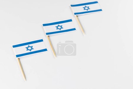 Téléchargez les photos : Gros plan de trois drapeaux d'Israël avec espace de copie sur fond blanc. Religion et tradition juives. - en image libre de droit