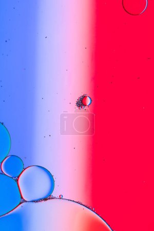 Téléchargez les photos : Macro gros plan des bulles d'eau avec espace de copie sur fond bleu, blanc et rouge. Concept de macro, couleur, eau, forme et motif. - en image libre de droit
