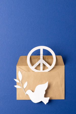 Photo for High angle view of white peace sign, white dove and leaf with copy space on blue background. Peace and anti war movement concept. - Royalty Free Image