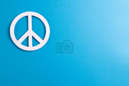 Foto de Vista de ángulo alto del signo de paz blanco con espacio de copia sobre fondo azul. Concepto de paz y movimiento contra la guerra. - Imagen libre de derechos