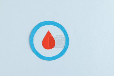 Foto de Gota de sangre en anillo azul sobre fondo azul con espacio para copiar. Azúcar en sangre, diabetes y conciencia de salud. - Imagen libre de derechos