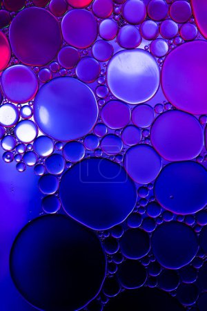 Foto de Macro primer plano de burbujas de agua con espacio de copia sobre fondo azul y púrpura. Concepto de macro, color, agua, forma y patrón. - Imagen libre de derechos
