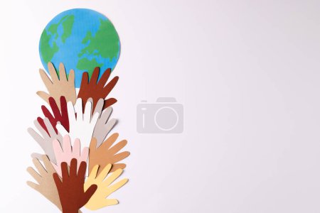 Foto de Papel cortado de manos multicolores con globo y espacio de copia sobre fondo blanco. Ayuda humanitaria, personas, ayuda y concepto humano. - Imagen libre de derechos