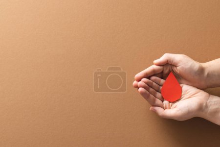 Téléchargez les photos : Mains de femme caucasienne coupant goutte de sang, sur fond brun avec espace de copie. Don de sang, médicaments et soins de santé. - en image libre de droit