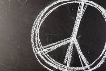 Photo for Close up of white chalk peace sign on black chalkboard background. Peace and anti war movement concept. - Royalty Free Image