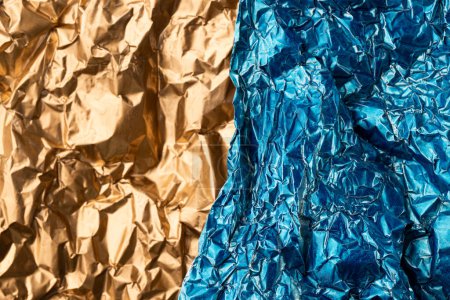 Photo for Close up of crumpled shiny gold and blue foil with copy space. Colour, texture and material. - Royalty Free Image