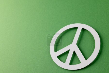 Foto de Vista de ángulo alto del signo de paz blanco con espacio de copia sobre fondo verde. Concepto de paz y movimiento contra la guerra. - Imagen libre de derechos