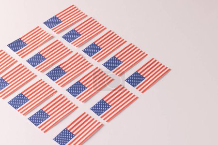 Téléchargez les photos : Rangées de drapeaux des États-Unis d'Amérique avec espace de copie sur fond blanc. Patriotisme américain, fête de l'indépendance et concept de tradition. - en image libre de droit