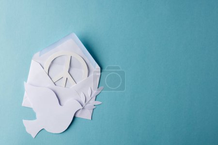 Photo for High angle view of white peace sign, white dove and envelope with copy space on blue background. Peace and anti war movement concept. - Royalty Free Image