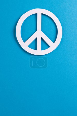 Foto de Vista de ángulo alto del signo de paz blanco con espacio de copia sobre fondo azul. Concepto de paz y movimiento contra la guerra. - Imagen libre de derechos