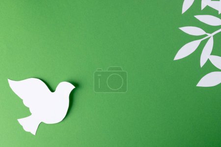 Photo for Close up of white dove with leaves and copy space on green background. Peace and anti war movement concept. - Royalty Free Image