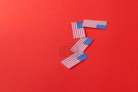 Téléchargez les photos : Vue en angle élevé de quatre drapeaux des États-Unis d'Amérique avec espace de copie sur fond rouge. Patriotisme américain, fête de l'indépendance et concept de tradition. - en image libre de droit