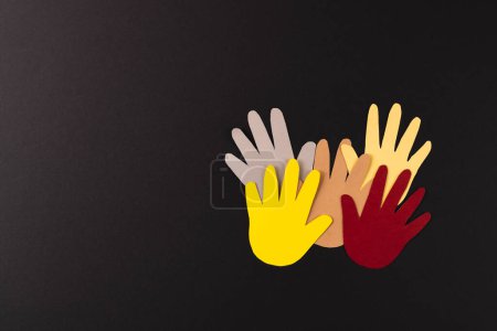 Foto de Cierre de papel cortado de manos multicolores con espacio para copiar sobre fondo negro. Humanitario, pueblo, ayuda y concepto humano. - Imagen libre de derechos