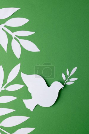 Photo for Close up of white dove with leaves and copy space on green background. Peace and anti war movement concept. - Royalty Free Image