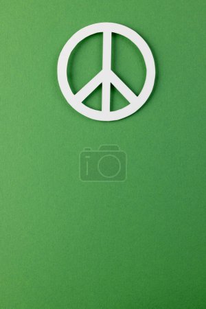 Téléchargez les photos : Vue grand angle de signe de paix blanc avec espace de copie sur fond vert. Concept de mouvement pour la paix et contre la guerre. - en image libre de droit