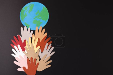 Foto de Papel cortado de manos multicolores y globo con espacio de copia sobre fondo negro. Ayuda humanitaria, personas, ayuda y concepto humano. - Imagen libre de derechos