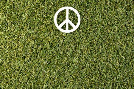 Foto de Vista de ángulo alto del signo de paz blanco con espacio de copia en el fondo de hierba. Concepto de paz y movimiento contra la guerra. - Imagen libre de derechos