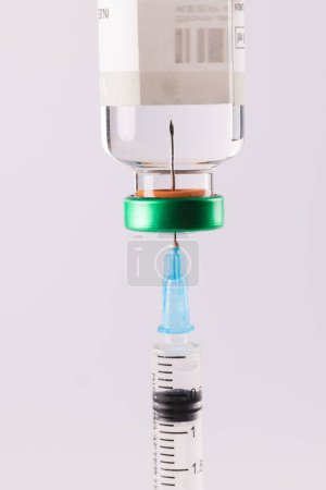 Téléchargez les photos : Remplissage de seringue à partir d'un flacon de liquide transparent tel que l'insuline, sur fond blanc. Glycémie, diabète et sensibilisation à la santé. - en image libre de droit