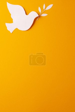 Téléchargez les photos : Gros plan de colombe blanche avec feuille et espace de copie sur fond jaune. Concept de mouvement pour la paix et contre la guerre. - en image libre de droit