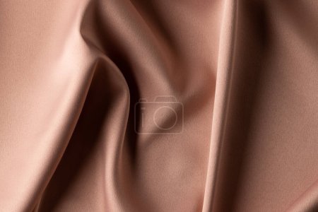Photo for Close up of plain beige satin fabric with folds, copy space. Colour, texture and material. - Royalty Free Image