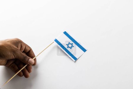 Téléchargez les photos : Gros plan de l'homme biracial drapeau de vacances d'Israël avec espace de copie sur fond blanc. Religion et tradition juives. - en image libre de droit
