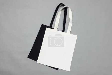 Téléchargez les photos : Vue grand angle des sacs en toile noir et blanc avec espace de copie sur fond gris. Sacs et concept de mode. - en image libre de droit