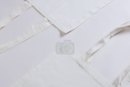 Foto de Vista de ángulo alto de dos bolsas de lona blanca con espacio de copia sobre fondo blanco. Bolsas y concepto de moda. - Imagen libre de derechos