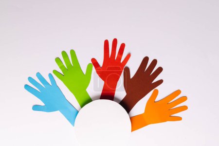 Photo for High angle view of paper multi coloured hands and white circle with copy space on white background. Humanitarian aid, humanity, people and help concept. - Royalty Free Image