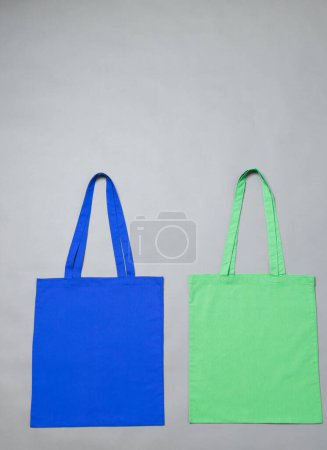 Téléchargez les photos : Vue grand angle des sacs en toile bleue et verte avec espace de copie sur fond gris. Sacs et concept de mode. - en image libre de droit