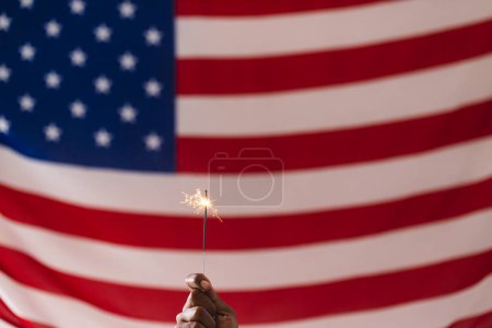 Téléchargez les photos : Main de l'homme biracial tenant scintillant et drapeau des États-Unis d'Amérique avec espace de copie. Patriotisme américain, fête de l'indépendance et concept de tradition. - en image libre de droit