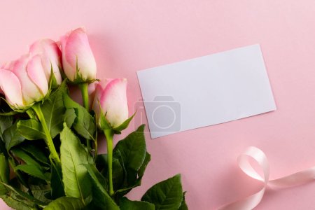 Foto de Imagen de tulipanes rosados con cinta y tarjeta con espacio para copiar sobre fondo rosado. Día de la madre, naturaleza y concepto de primavera. - Imagen libre de derechos