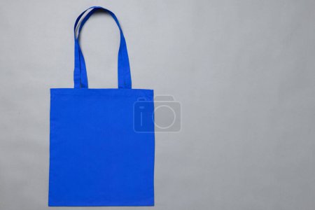 Foto de Vista de ángulo alto de la bolsa de lona azul con espacio de copia sobre fondo gris. Bolsas y concepto de moda. - Imagen libre de derechos