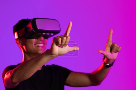 Photo for Happy asian man using vr headset in studio with purple light with copy space. Virtual reality and digital interface technology. - Royalty Free Image