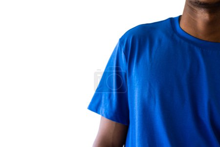 Téléchargez les photos : Milieu de l'homme afro-américain portant un t-shirt bleu avec espace de copie sur fond blanc. Vêtements, mode, style et design. - en image libre de droit