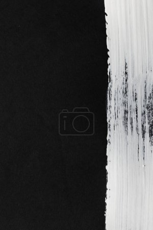 Téléchargez les photos : Gros plan de la bande de peinture blanche sur fond noir avec espace de copie. Fond, motif et couleur abstraits. - en image libre de droit