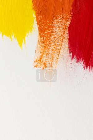 Foto de Primer plano de las formas de pintura amarilla, naranja y roja sobre fondo blanco con espacio para copiar. Fondo, patrón y color abstractos. - Imagen libre de derechos