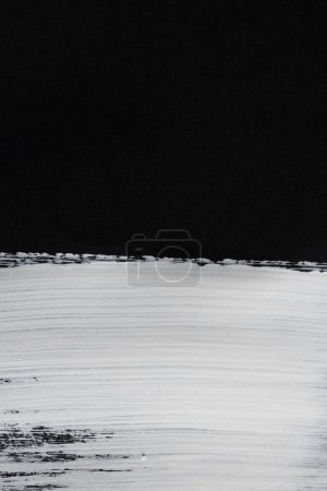 Téléchargez les photos : Gros plan de la bande de peinture blanche sur fond noir avec espace de copie. Fond, motif et couleur abstraits. - en image libre de droit