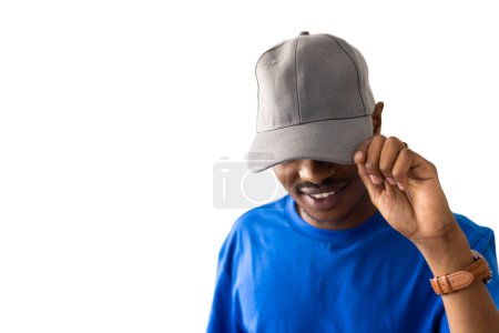 Téléchargez les photos : Homme afro-américain portant un t-shirt bleu et une casquette grise avec un espace de copie sur fond blanc. Vêtements, mode, style et design. - en image libre de droit