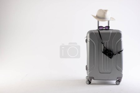 Photo for Suitcase with straw hat, sunglasses and camera on white background with copy space. Travel and vacation. - Royalty Free Image