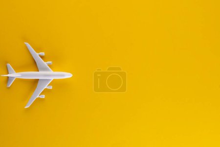 Close up of airplane model on yellow background with copy space. Travel, transport and vacation.