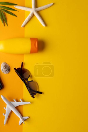 Foto de Modelo de avión, gafas de sol, protector solar, plantas y conchas marinas sobre fondo amarillo con espacio de copia. Viajes, transporte y vacaciones. - Imagen libre de derechos