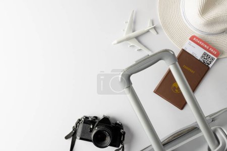 Téléchargez les photos : Modèle d'avion, chapeau de paille, passeport, appareil photo et valise sur fond blanc avec espace de copie. Voyages, transports et vacances. - en image libre de droit