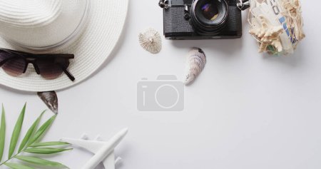 Photo for Close up of hat, sunglasses, camera, seashells and plane model on white background with copy space. Travel, vacation and summer. - Royalty Free Image