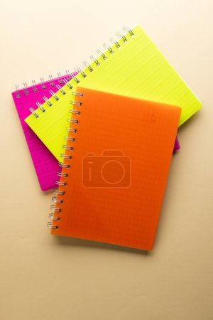 Téléchargez les photos : Carnets multicolores et espace de copie sur fond orange. Concept de lecture, d'apprentissage, d'école et d'éducation. - en image libre de droit
