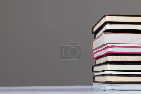 Téléchargez les photos : Gros plan de la pile de livres et carnets avec espace de copie sur fond gris. Concept de lecture, d'apprentissage, d'école et d'éducation. - en image libre de droit